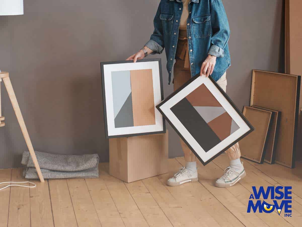 A person carefully packing framed artwork, highlighting best practices for Moving Art safely