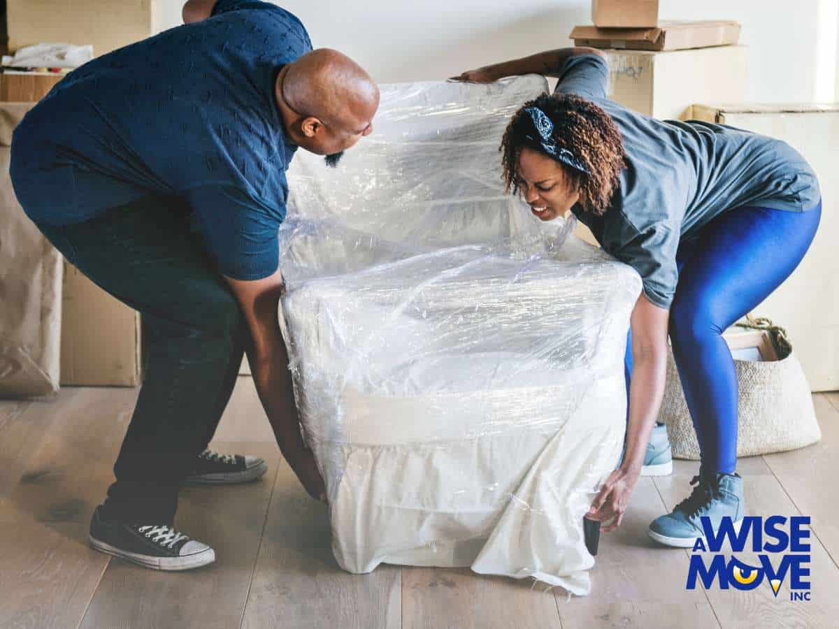 Two people working together to move heavy furniture carefully